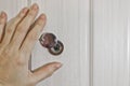 A female hand opens the shutter on the door peephole in the front door. The concept of security Royalty Free Stock Photo