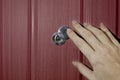 A female hand opens the shutter on the door peephole in the front door. The concept of security Royalty Free Stock Photo