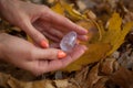 Female hand with orange manicure holding transparent violet amethyst yoni egg for vumfit, imbuilding or meditation on Royalty Free Stock Photo