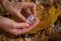 Female hand with orange manicure holding transparent violet amethyst yoni egg for vumfit, imbuilding or meditation on Royalty Free Stock Photo