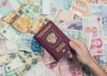 Female hand with passport and money of south-east Asia and American hundred dollar bill. Currency Royalty Free Stock Photo