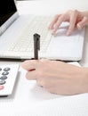 Female hand with pen, notebook and calculator at desktop Royalty Free Stock Photo