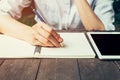 Female hand with pencil writing on notebook. Woman hand with pen