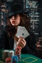 Female hand with playing cards and poker chips close-up in front of poker table. poker concept Royalty Free Stock Photo