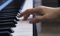 A female hand is playing the electronic digital piano at home. The woman is a professional pianist who arranges music using