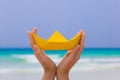 Female hand playing with yellow paper boat on the beach Royalty Free Stock Photo