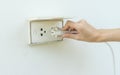 Female hand plugging in appliance to electrical outlet in wall o Royalty Free Stock Photo