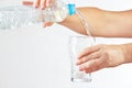 Female hand pour water into a glass from bottle Royalty Free Stock Photo