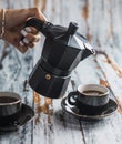 Female hand pouring coffee into an espresso cup with an italian coffee maker. Royalty Free Stock Photo