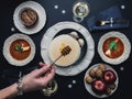 Female hand pouring honey on Christmas Eve wafers. Table with Christmas dinner Royalty Free Stock Photo