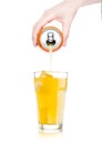 Female hand pouring orange soda from can to glass Royalty Free Stock Photo