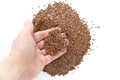 Female hand pours flax seeds.