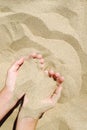 female hand pours sand through his fingers on seashore Royalty Free Stock Photo