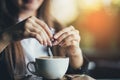 Female hand pours sugar into coffee. Sunlight background Royalty Free Stock Photo