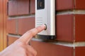 The female hand presses a button doorbell with intercom Royalty Free Stock Photo