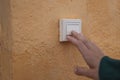 Female hand presses the doorbell button on the street close-up .there is a place for the inscription Royalty Free Stock Photo