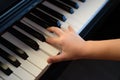 A female hand presses the piano keys. Early musical development in young children