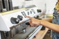 Female hand pressing button on panel of coffeemachine