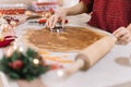 Female hand pressing cookie form on rollout dough