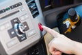 Female hand pressing emergency light button on car dashboard. Royalty Free Stock Photo