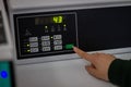 Female hand pressing start button on washing machine control panel Royalty Free Stock Photo