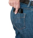 Female hand pulling a wallet or purse out of a blue jeans pocket