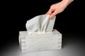 Female hand pulling white facial tissue from a box Royalty Free Stock Photo