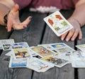 Female hand throws tarot card named Temperance over plank surface with cards laid face up. Minsk, Belarus, 28.07.2021 Royalty Free Stock Photo