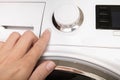 Female hand pushing start stop button of washer, washing machine cycle interraption or starting, beginning Royalty Free Stock Photo