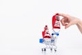 Female hand puts baby red sneakers into the shopping cart isolated on white background. Online store of children's shoes. Royalty Free Stock Photo