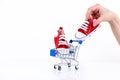 Female hand puts baby red sneakers into the shopping cart isolated on white background. Online store of children's shoes. Royalty Free Stock Photo