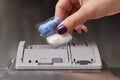 female hand puts dishwasher tablet into dishwasher machine Royalty Free Stock Photo