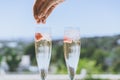 Female hand puts ice into a glasses champagne with strawberry inside on sunny terrace overlooking beautiful view at Royalty Free Stock Photo