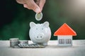 Female hand putting a coin into piggy bank, concept of saving money for house, Savings money for buy house and loan to business Royalty Free Stock Photo