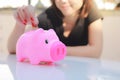 Female hand putting money into piggy bank. Royalty Free Stock Photo