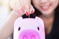 Female hand putting money into piggy bank. Royalty Free Stock Photo