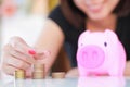 Female hand putting money into piggy bank. Royalty Free Stock Photo