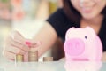 Female hand putting money into piggy bank. Royalty Free Stock Photo