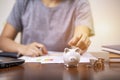 Female hand putting money into piggy bank for saving money, write finance Royalty Free Stock Photo