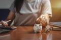 Female hand putting money into piggy bank for saving money, write finance Royalty Free Stock Photo