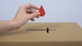 Female hand putting red drop sign in church box, blood donation, donor day