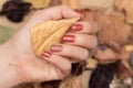 Female hand with red autumn nail design. Woman hand hold dry leaf. Red autumn nail polish manicure with golden glitter Royalty Free Stock Photo