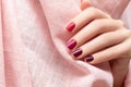 Female hand with red gradient nail design. Perfect glitter red nail polish manicure. Red fingernails female hand on pink fabric Royalty Free Stock Photo