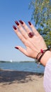 Female hand with red long nails and a bottle Royalty Free Stock Photo