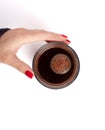 Female hand with red matte manicure holds a glass of coffee top view.  on white background Close up. Enjoy a cup Royalty Free Stock Photo