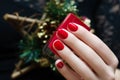 Female hand with red nail design holding nail polish bottle Royalty Free Stock Photo