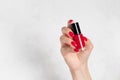 Female hand with red nail design holding nail polish bottle. Perfect nails Royalty Free Stock Photo