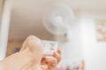Female hand with remote control Blurred image of fan aircondition. Royalty Free Stock Photo