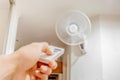 Female hand with remote control Blurred image of fan aircondition. Royalty Free Stock Photo