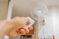 Female hand with remote control Blurred image of fan aircondition. Royalty Free Stock Photo